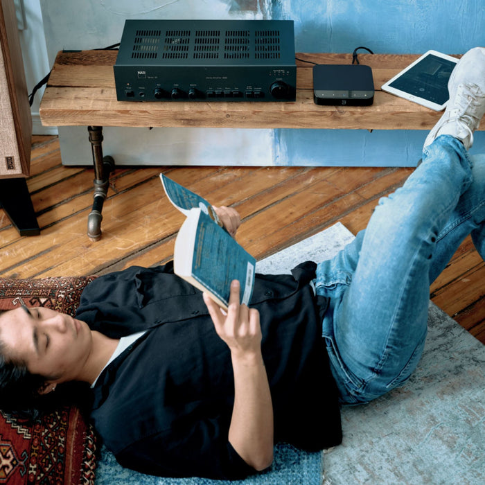 Bluesound Node Nano Wireless Network Streamer lifestyle shot, nano in listening room with person reading