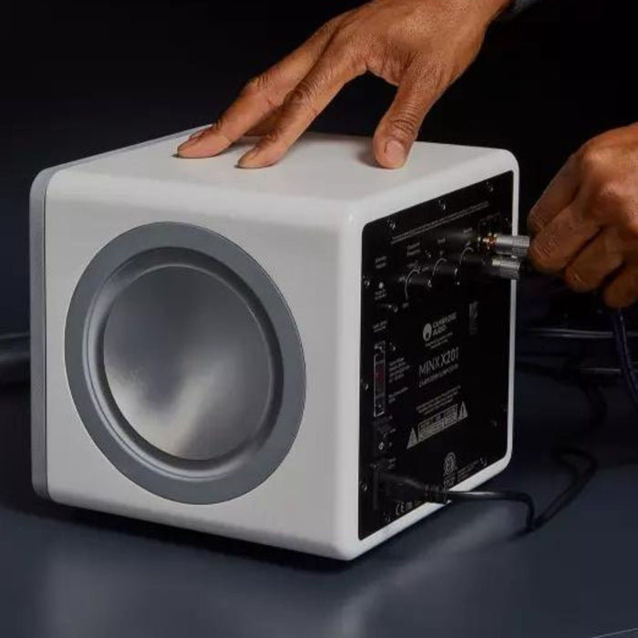 man plugging in cambridge audio x201 subwoofer in