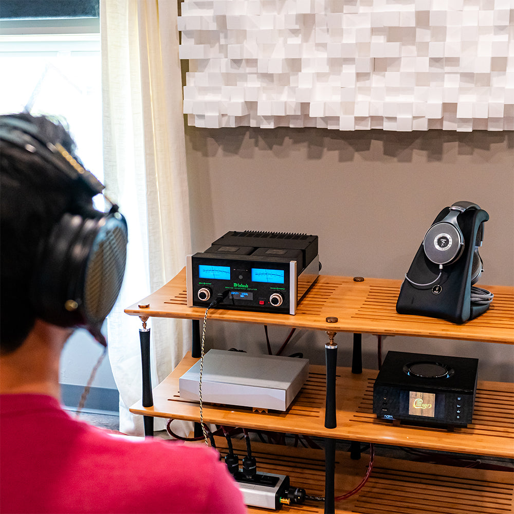 Person listening to Audeze headphones on a McIntosh headphone amplifier